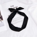 Schwarzes Wildleder-Stirnband mit Schleife für Damen auf einem Modemagazin drapiert - Schwarz