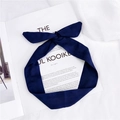 Bandeau en suédine bleu marine avec un nœud papillon posé sur un magazine blanc - Bleu marine