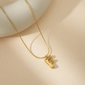 Detalle macro del colgante letra F burbuja en oro 18K con una fina cadena de serpiente - F Con Cadena de Serpiente