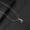 Detailopname van de zilveren bubble letter J hanger aan een gladde slangenketting - Letter J / Met Slangenketting
