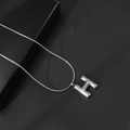 Macro-opname van 3D bubble letter H hanger aan een hoogglans zilveren slangenschakel - Letter H / Met Slangenketting