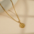 Gold Figaro chain necklace with a vintage Capricorn coin pendant on a beige background - Capricorn