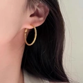 Twisted rope texture gold hoop earrings worn by a model in a close-up profile view - 3cm / Gold