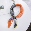 Floral and geometric patchwork silk scarf in gray, orange, and blue on white surface - Orange Gray Patchwork