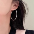Large silver-colored twist hoop earrings with woven texture on model's ear - 5cm / Silver