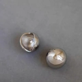 Macro shot of S925 sterling silver sphere earring showing the metal hallmark and polish - Silver