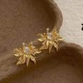 Close-up of vintage flower earrings with central zircon stone and gold-plated petals - Gold