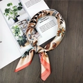 Detailed shot of a satin silk scarf with vintage leaf prints on a wooden magazine background - 60x60cm / Palm Pattern Orange
