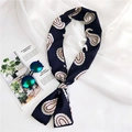 Detail of navy blue paisley silk scarf styled with sunglasses on white fabric - Navy Blue Paisley