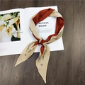 Detail of elegant two-tone beige and caramel satin twilly scarf with cursive print - Red Letter Print