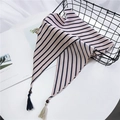 Sciarpa a triangolo a righe beige con nappine in legno su un cesto nero - Righe Beige Rosa