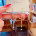 Detail of red crystal maple leaf earrings with long gold tassel chains on display card - Red Maple Leaf Long Ear Hooks