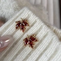Detail of maple leaf earrings with red crystals pinned on a white knitted sweater - Red Maple Leaf Stud Earrings