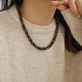 Tijgeroog stenen kralenketting met zijdeglans textuur op een beige gebreide trui - 8mm Tijgeroog Ketting