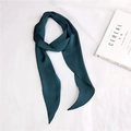 Macro shot of dark green silk scarf on white fabric next to a lifestyle magazine - Dark Green