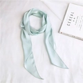 Close-up of mint green silk ribbon scarf with soft satin luster on magazine background - Pale Green