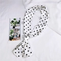 Primo piano di un foulard di seta lungo a pois bianchi e neri con finitura lucida - Bianco