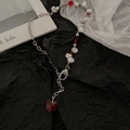 Collar de perlas barrocas con colgante de corazón rojo sobre fondo negro texturizado - Collar de Corazón Rojo