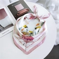 Pink flamingo and tropical leaf print silk scarf tied in a stylish knot on a white desk - Flamingo Pink