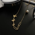 Elegant 18k gold butterfly necklace featuring asymmetric chains and a white pearl accent - Gold