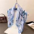 Carré de soie bleu clair à motifs floraux blancs suspendu sur un cintre blanc - Bleu / 70x70cm
