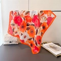 Dettaglio di un foulard di seta con stampa floreale vivace e consistenza satinata liscia - Arancione Rosso (FG107-2)
