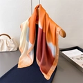 Seidiges quadratisches Halstuch mit geometrischem Farbmuster auf einem Holzbügel - Dunkelorange