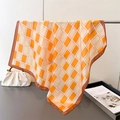 Detail van een oranje en wit geruite zijden sjaal die aan een zilveren metalen staaf hangt - 70cmx70cm / Oranje