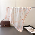 Classic white silk square scarf with orange geometric polka dots draped on a metal stand - Orange