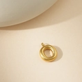 Colgante de anillo dorado minimalista con textura de líneas sobre base beige - Colgante Letra O