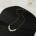 Titanium steel necklace with nine white pearls on a gold chain in a minimalist layout - Gold