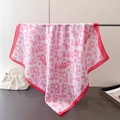 Pink and white geometric silk scarf displayed hanging next to a white pearl handbag - Square / Pink