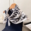 Close-up of black and white zebra pattern silk scarf styled on a navy blue top - 66-70CM / Black and Gray