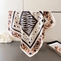 Detail of zebra and leopard print silk scarf elegantly draped on a metal hanging rack - 66-70CM / Brown