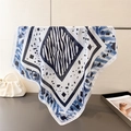 Close-up of zebra pattern silk scarf with blue geometric edges hanging on metal stand - 66-70CM / Blue
