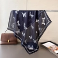 Dettaglio di un foulard blu navy setoso con stampe a farfalla bianca su supporto in metallo - 66-70cm / Nero
