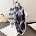 Pleated silk-like square scarf with black and white ink print hung on a hanger - Dark Grey