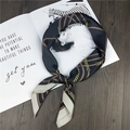 Elegant silk scarf with golden chain pattern on dark background over a fashion magazine - Black Line Chain