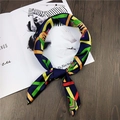 Navy blue satin silk scarf with tropical geometric prints on a wooden desk with a magazine - Line Totem