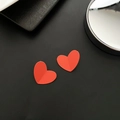 Matte red heart-shaped earrings featuring a modern 3D folded texture on black background - Heart Style / Red