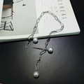 Silver paperclip chain necklace with three white pearl charms on minimalist background - Silver