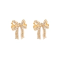 Detail of gold bow earrings with white enamel coating and shimmering crystal studs - White