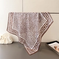 Detail of leopard print silk scarf with geometric border hanging on a metal rack - Coffee (FG150-4) / 66-70cm