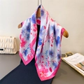 Sciarpa di seta con stampe floreali blu e rosa drappeggiata su un appendino in legno - Rosa Rossa