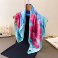 Floral print silk scarf in sky blue and pink draped on a wooden hanger with a white bag - Tropical Floral Blue Style (FG105-4)
