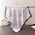 Dettaglio di un foulard in seta a motivi geometrici appeso a un supporto in metallo - 70x70cm / Bordo Nero (FG119-1)