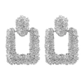 Detail view of silver geometric earrings with intricate star floral relief textures - Silver