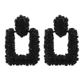 Macro view of black geometric drop earrings with textured relief and hollow rectangular design - Black