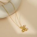 Collier doré avec pendentif lettre X bombé au fini poli sur fond minimaliste chic - Lettre Bulle X (Avec Chaîne Cruciforme)