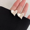 Detail of silver irregular heart earrings with a unique crushed metal texture finish - Silver